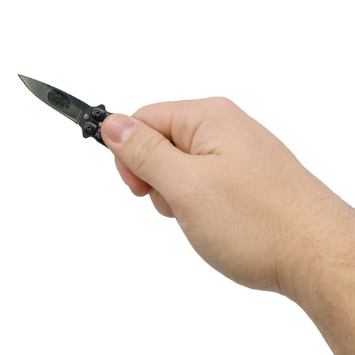 Mini butterfly knife keychain held in hand showing compact size