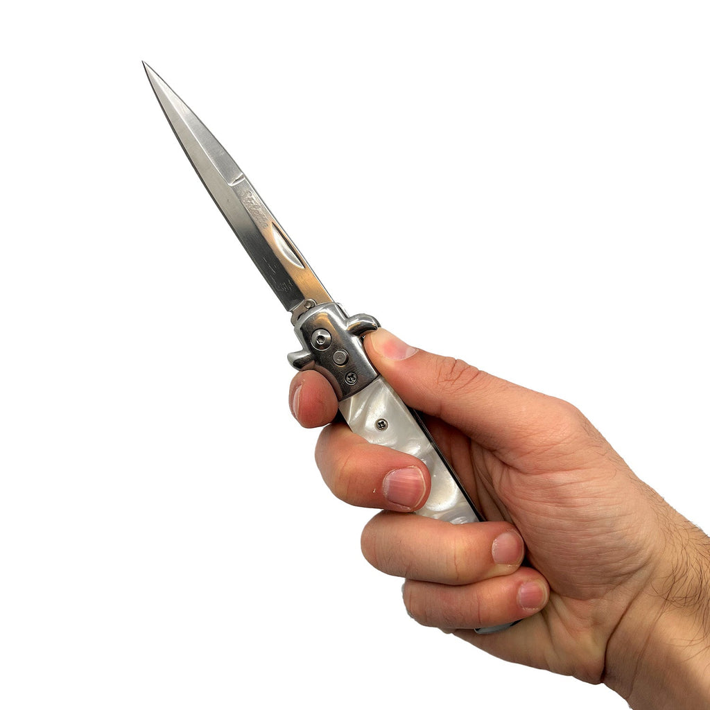 Person holding Stiletto automatic knife with white pearl handle and stainless blade